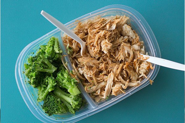 top down photo of packed lunch with broccoli and pulled chicken. Healthy lunch ideas to get a head